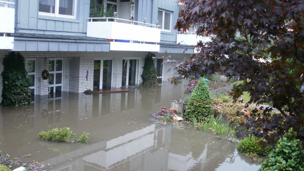 Überschwemmung in einem Wohngebiet: Das Wasser steht bis zu den Türklinken im Erdgeschoss